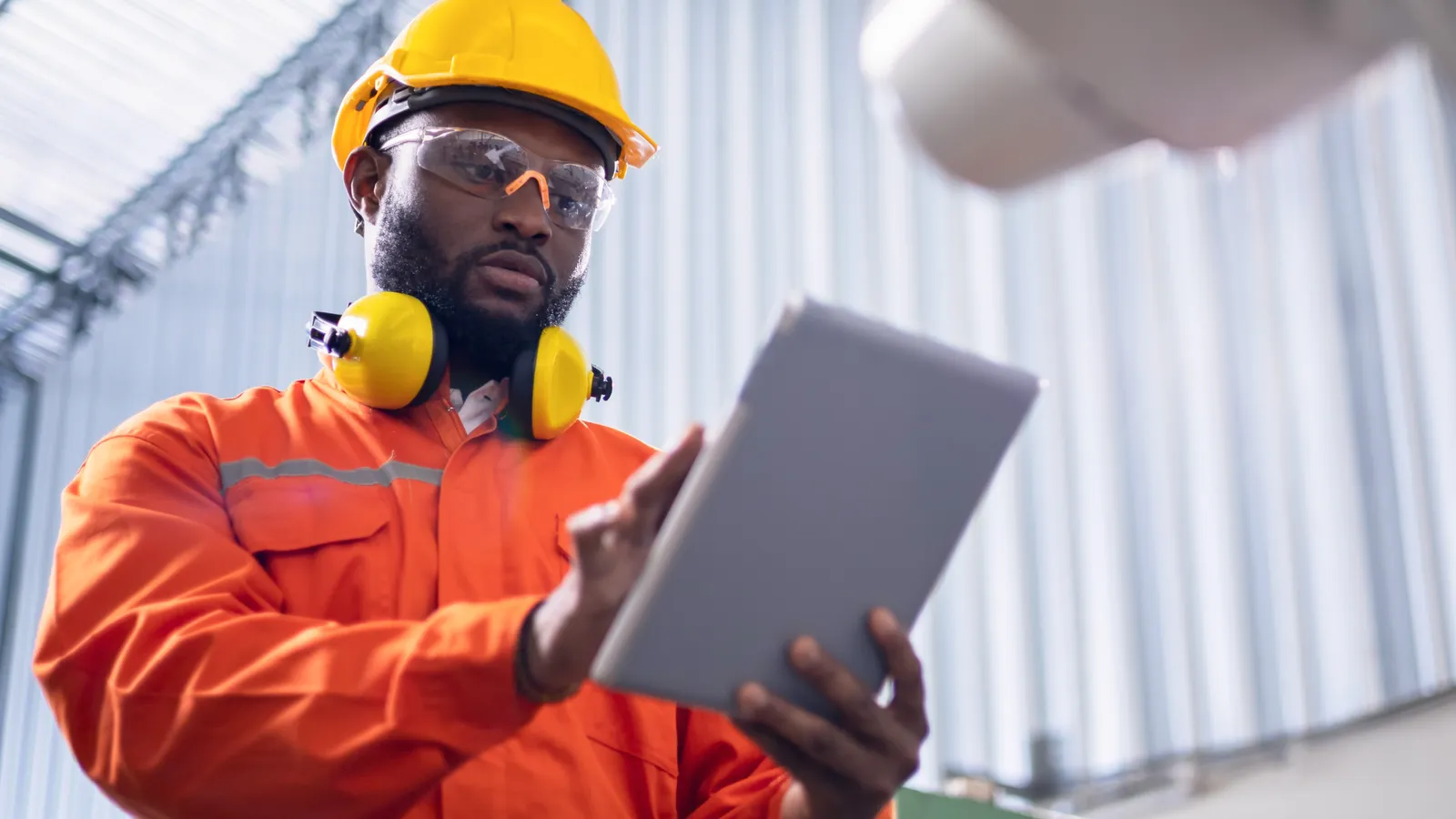 Photo of engineer in hard hat using tablet