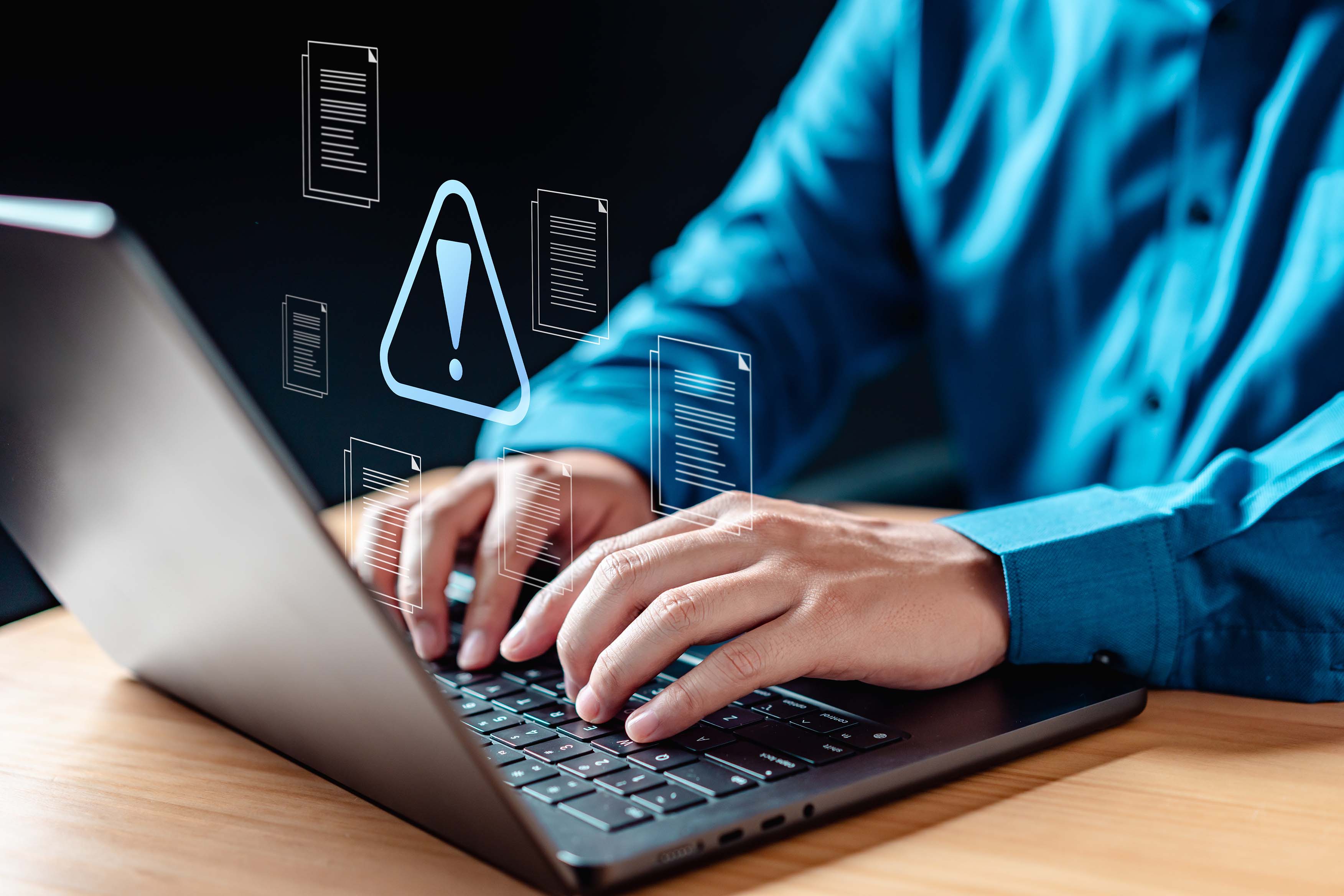 Photo of man's hands typing with security notification superimposed