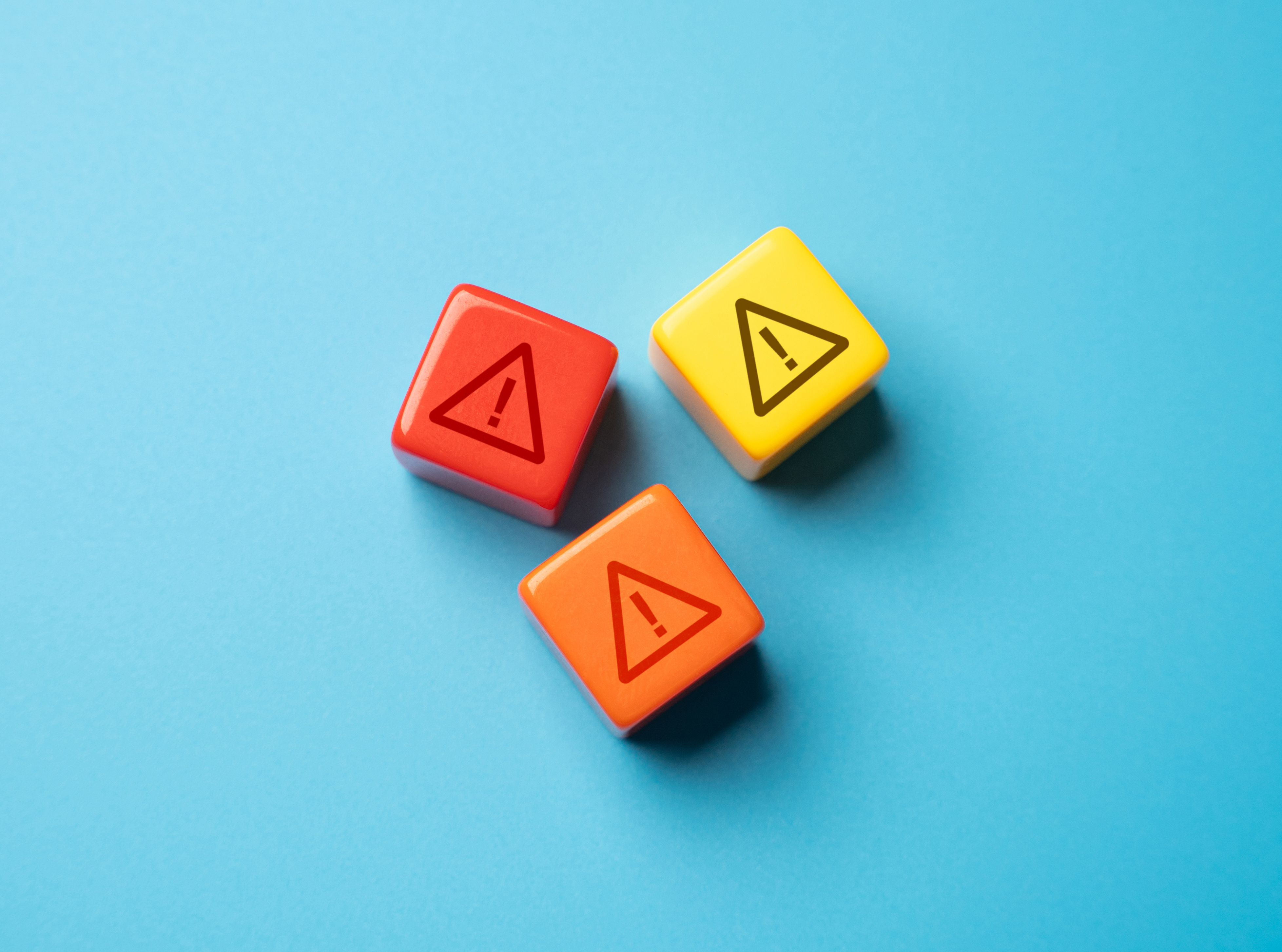 Stock photo of dice rolled and landing on warning symbol