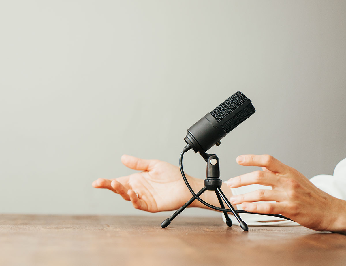 Photo of hands gesturing behind a microphone