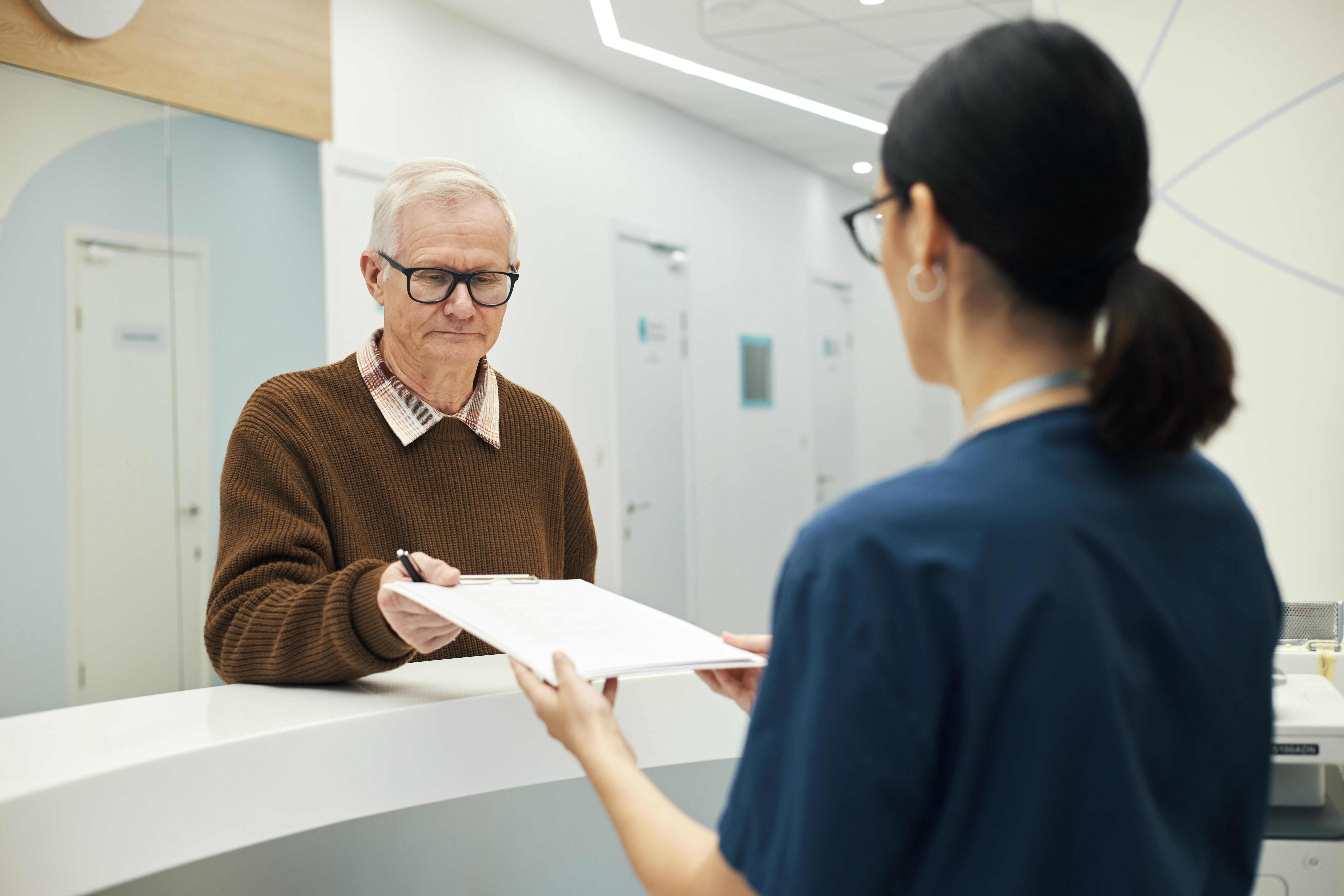Elderly white patient at hospital registration desk